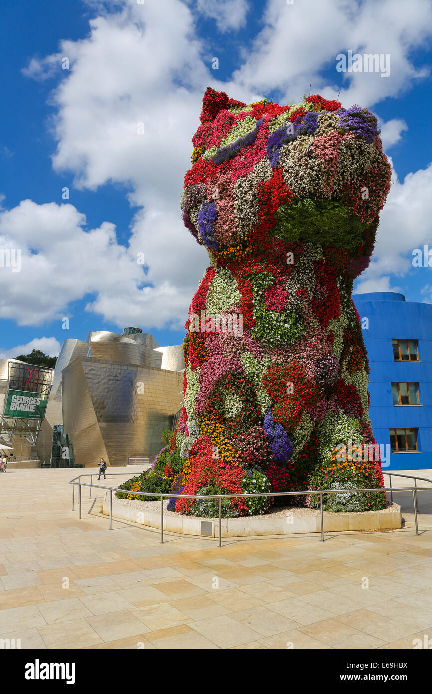 BILBAO, Spagna - 10 luglio 2014: persone non identificate hanno vicino l'opera d'arte 'Cucciolo" di Jeff Koons di fronte al famoso museo Guggenheim Foto Stock