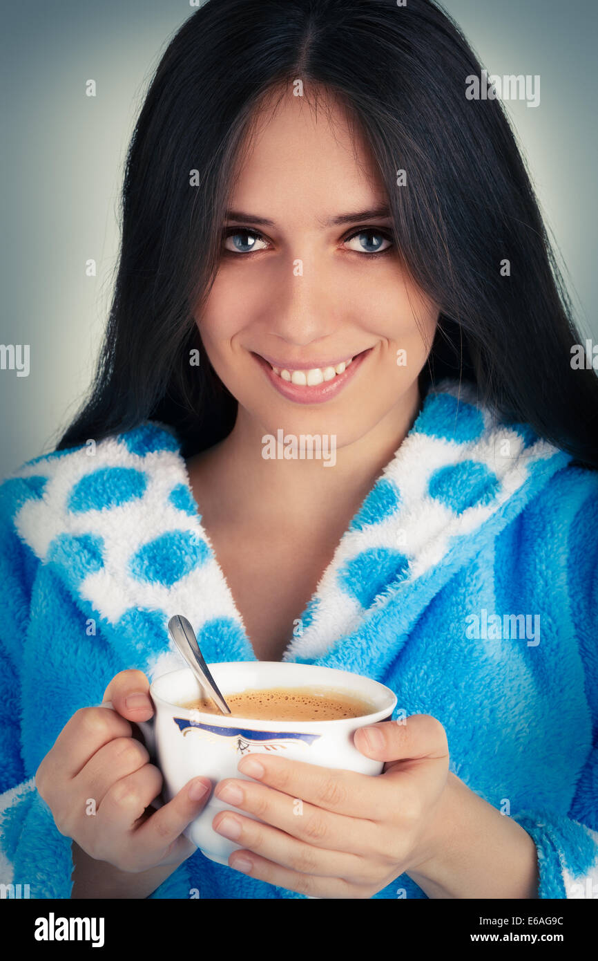 Giovane donna in accappatoio tenendo una grande tazza di caffè Foto Stock