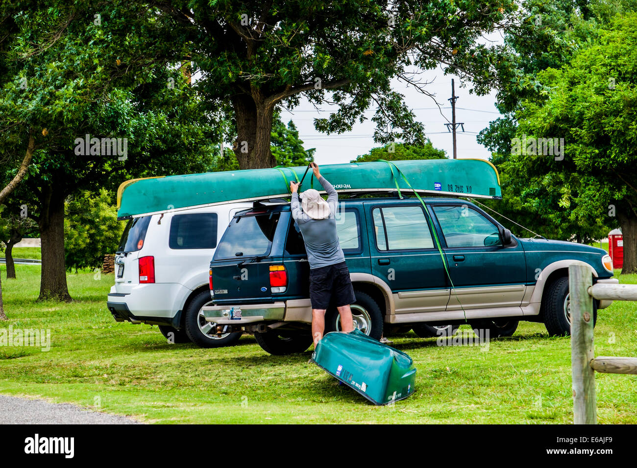 Un uomo fissa una canoa sulla sommità del suo veicolo in un lago di Oklahoma. Oklahoma City, Oklahoma, Stati Uniti d'America. Foto Stock
