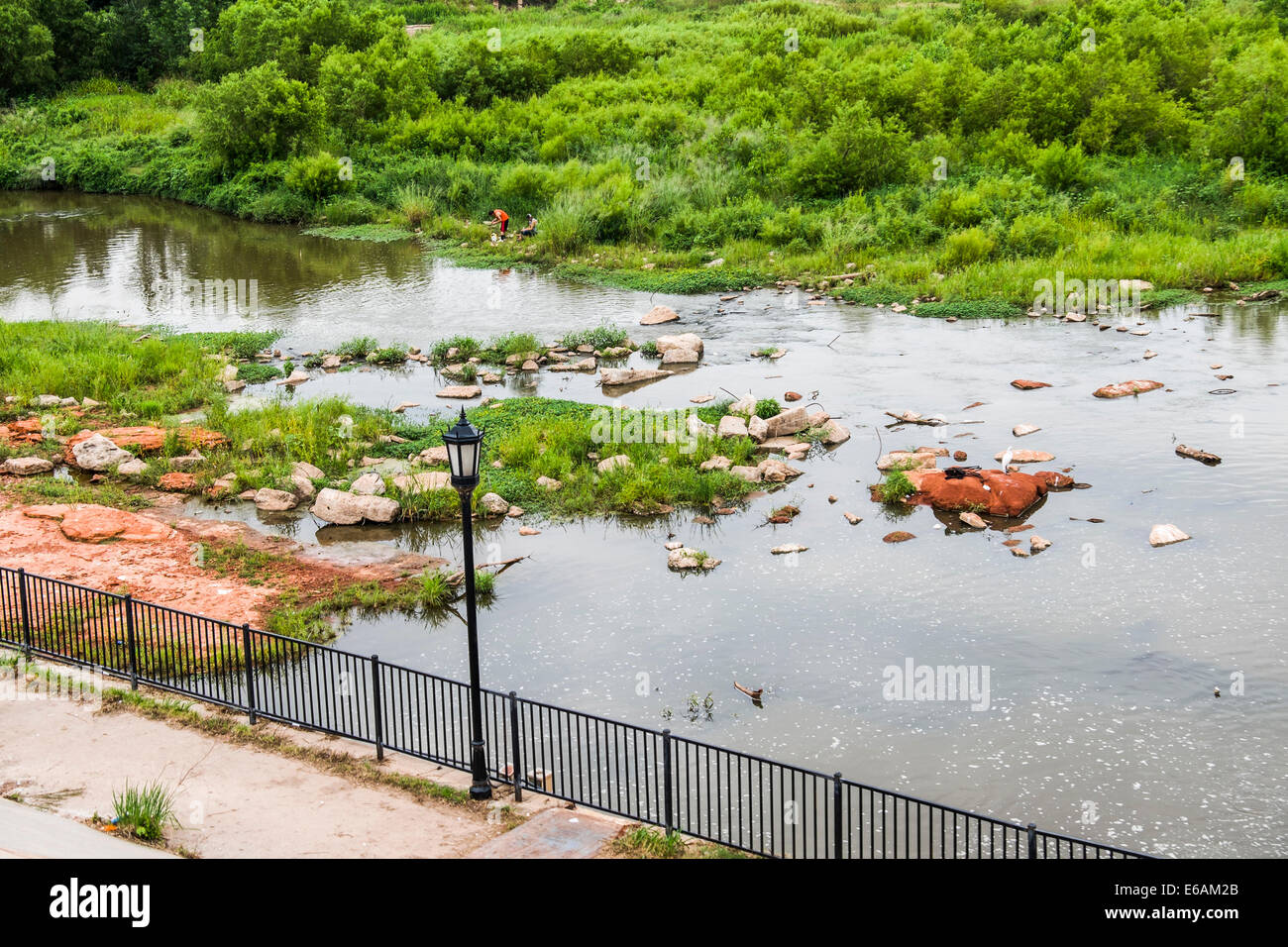 Il nord del fiume canadese al di sotto del lago diga Overholser con due uomini ispanica la pesca sulla riva lontana. Oklahoma, Stati Uniti d'America. Foto Stock