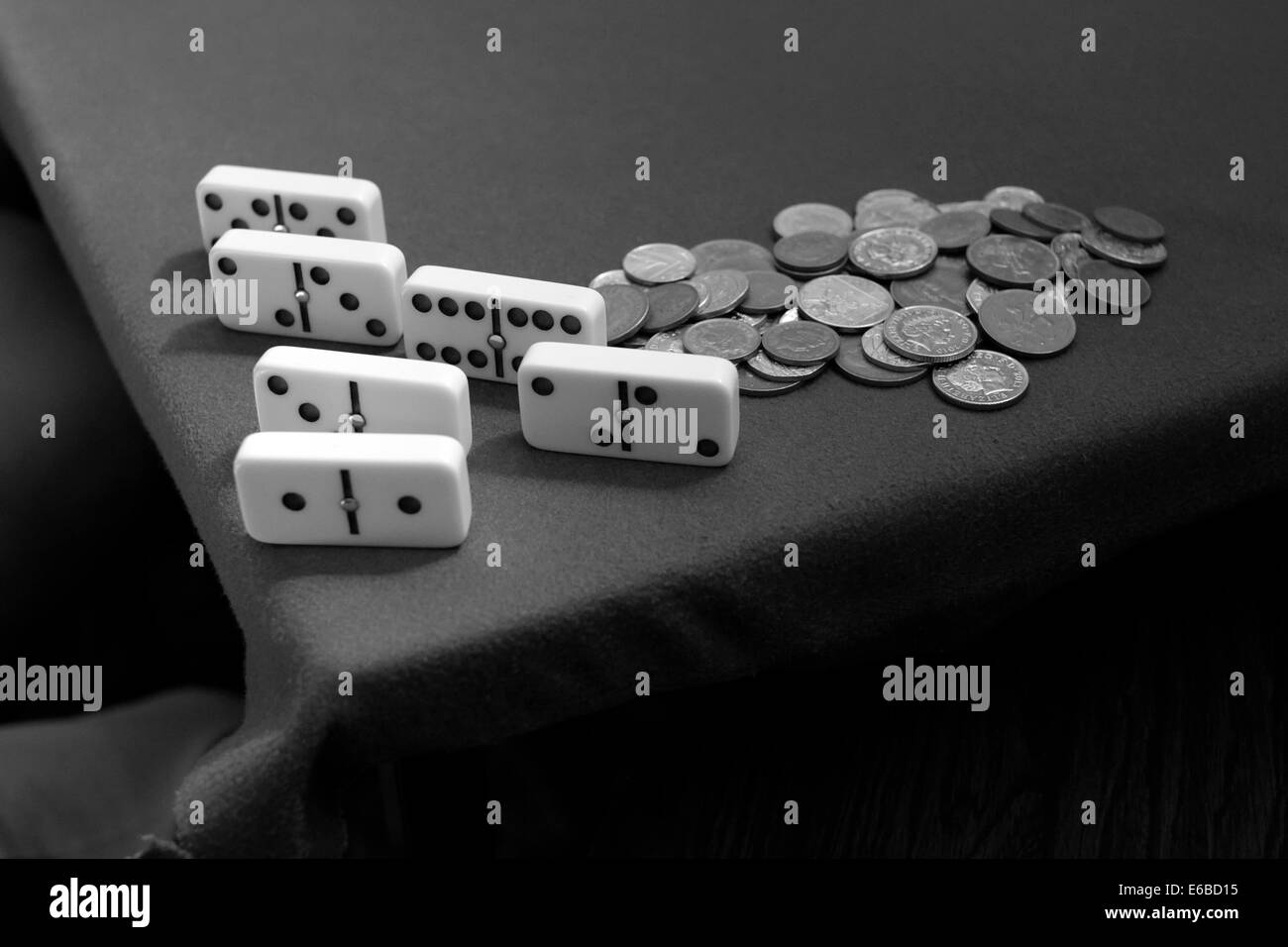 Domino tradizionale e una pila di monete su un tavolo durante una partita Foto Stock