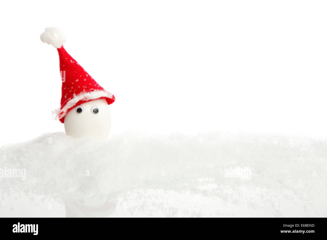 Uovo di bianco vestito come un Nicola con neve davanti a uno sfondo bianco Foto Stock