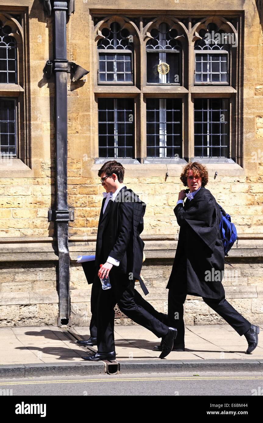 Gli studenti a piedi lungo la strada alta indossando abiti accademici, Oxford, Oxfordshire, Inghilterra, Regno Unito, Europa occidentale. Foto Stock