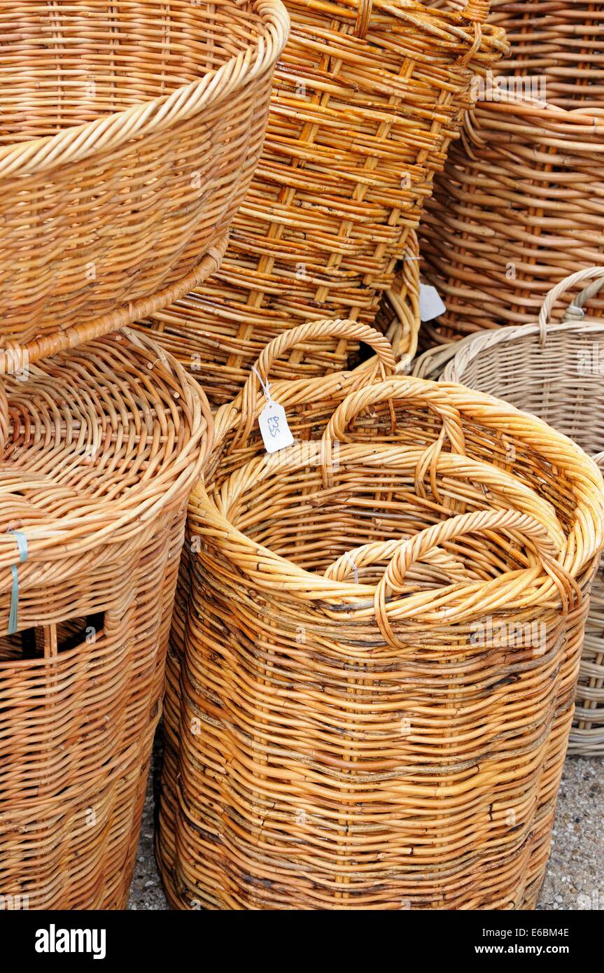 Tradizionali canestri di vimini per la vendita al di fuori di un negozio lungo la High Street, Burford, Oxfordshire, Inghilterra, Regno Unito, Europa occidentale. Foto Stock