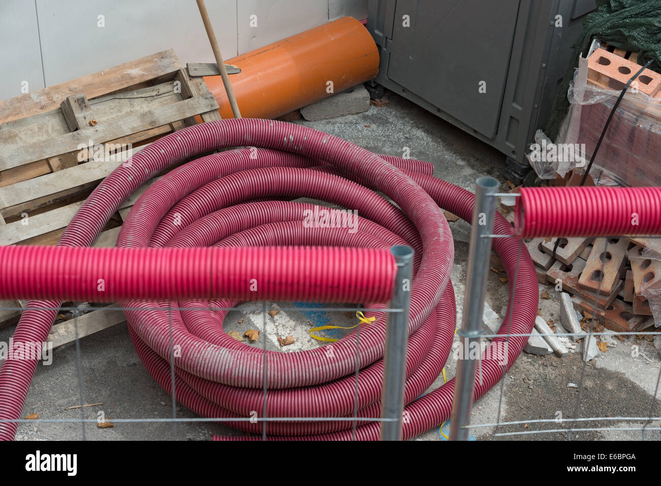 La pila di materiali per le comunicazioni urbane alla riparazione presso la strada all'aperto posto oltre il recinto. Foto Stock