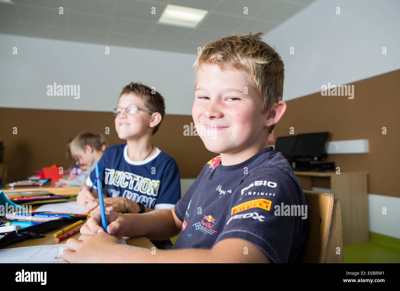 Bambini seduti in una scuola primaria classe durante una lezione di disegno, Reith im Alpbachtal, distretto di Kufstein, Tirolo, Austria Foto Stock