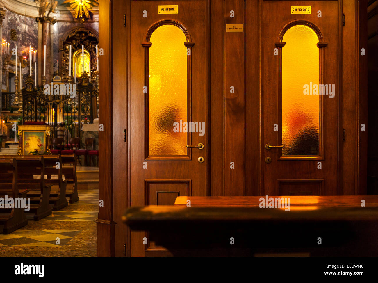 Sacerdote audizione confessione nel confessionale booth nella Chiesa cattolica romana con il Santuario della Madonna di San Luca a Bologna Foto Stock