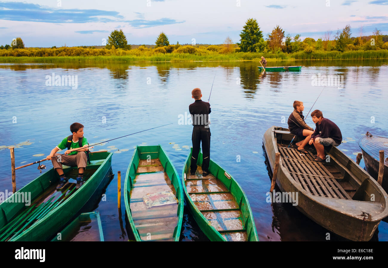 MINSK, Bielorussia - 25 Luglio: bambini bielorussi pesca dalle vecchie barche al tramonto di un giorno di estate in Luglio 25, 2013 a Minsk, Belaru Foto Stock