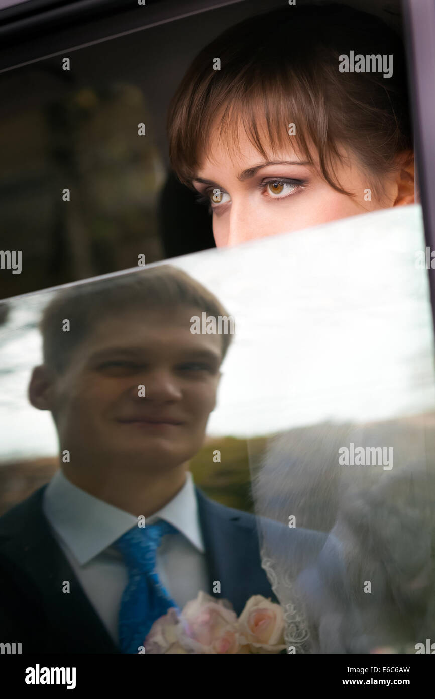 Sposa guardando attraverso la finestra auto-NOZIONE Foto Stock