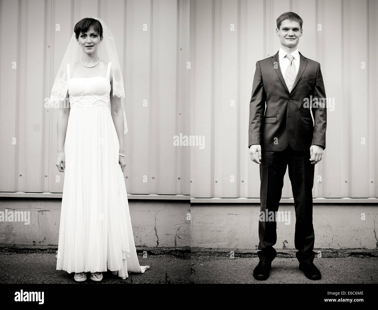 A piena lunghezza ritratto della sposa e lo sposo in piedi contro la parete Foto Stock