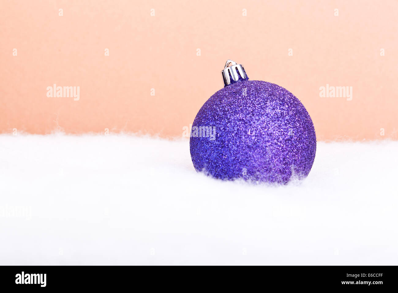 Viola scintillante palla di Natale su il caldo colore di sfondo Foto Stock