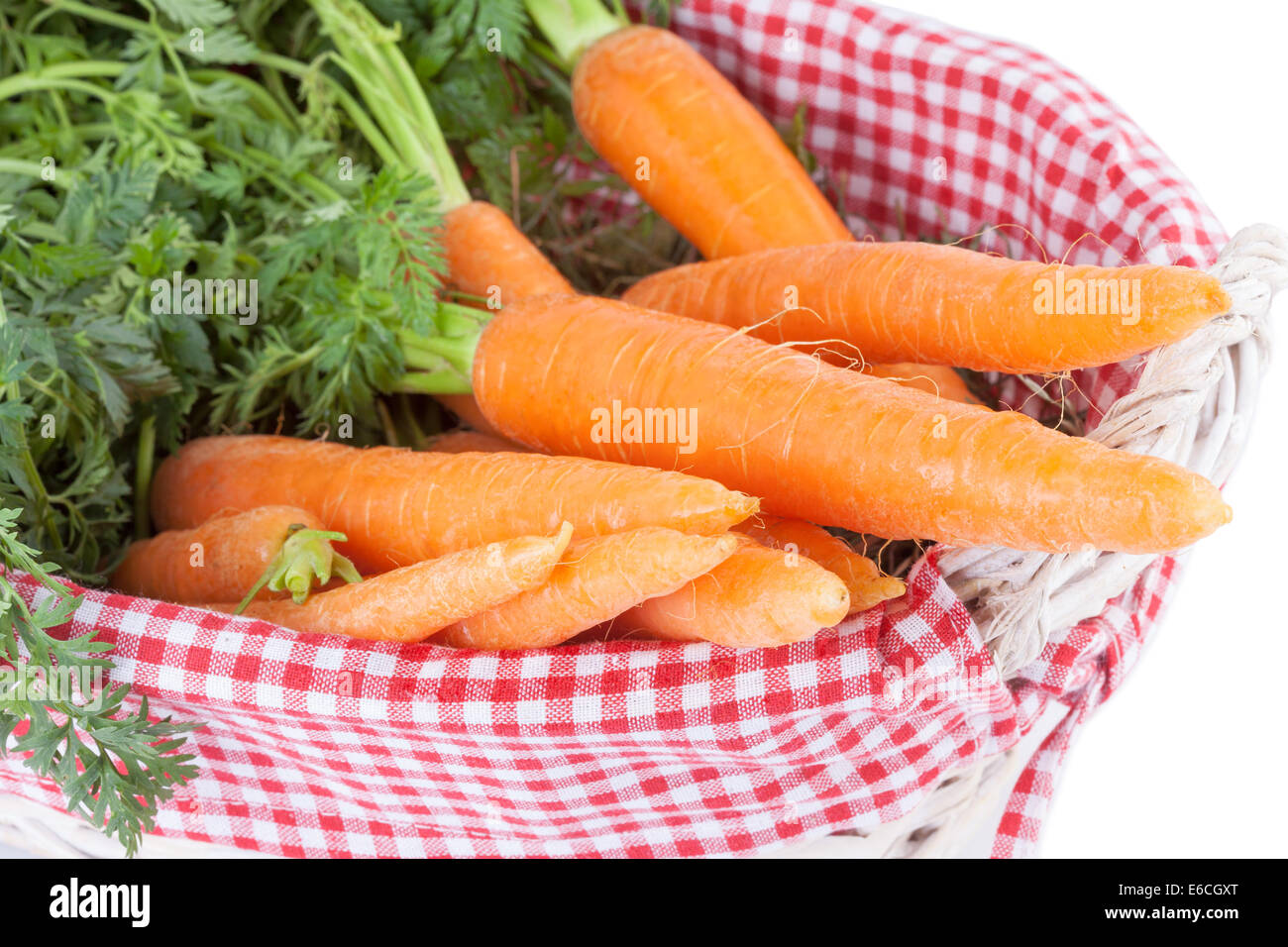 Le carote fresche con foglie in un cestello Foto Stock