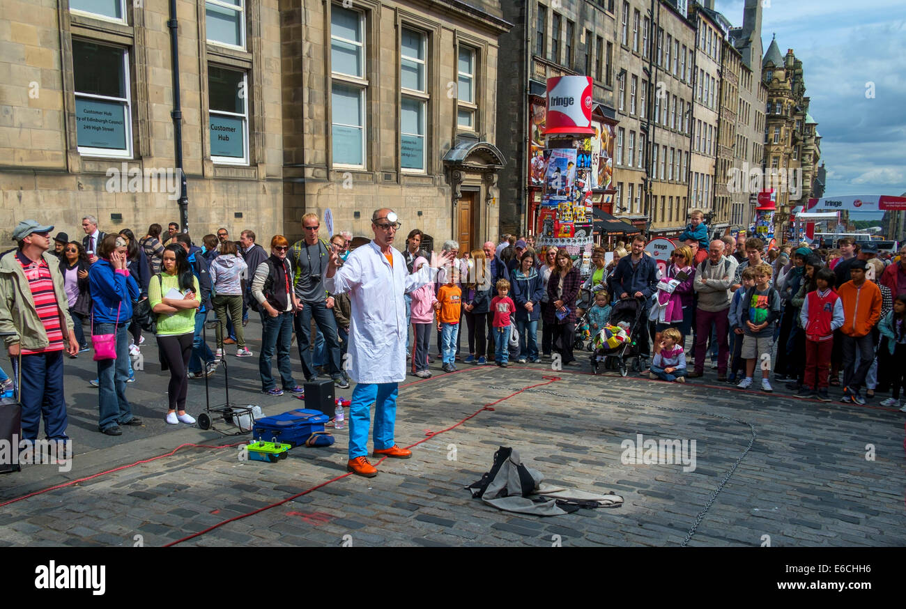 Gli artisti interpreti o esecutori della frangia di intrattenere e promuovere il loro show in High Street, Edimburgo Foto Stock