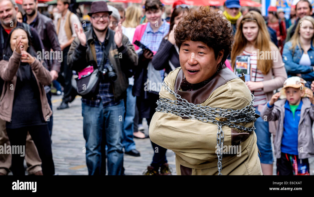 Un escapologist intrattiene nell'High Street, Edimburgo durante il Fringe Festival Foto Stock
