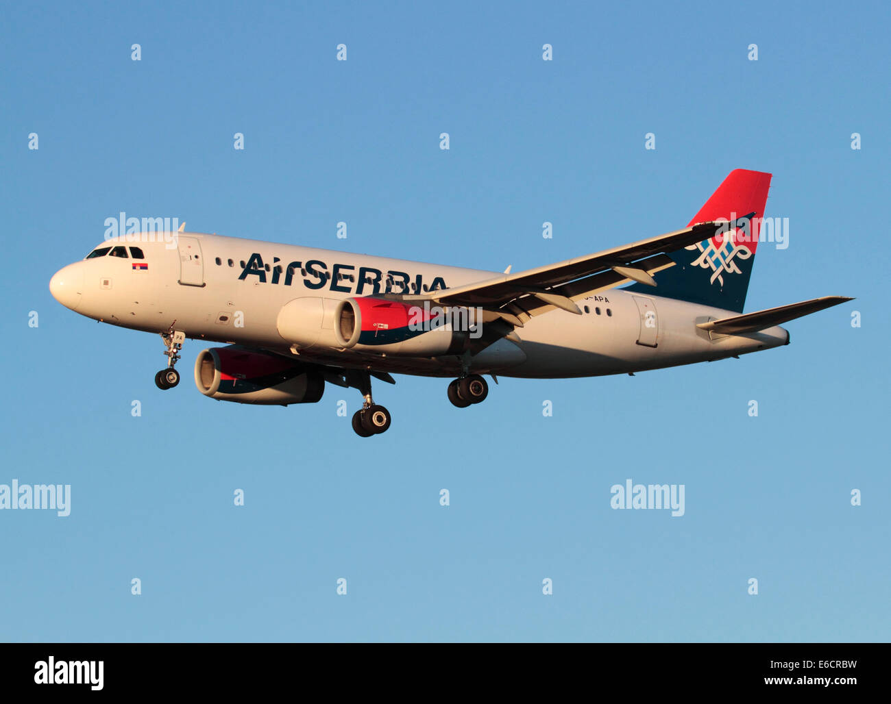 Aria Serbia Airbus A319 sull approccio finale al tramonto contro un cielo blu chiaro Foto Stock