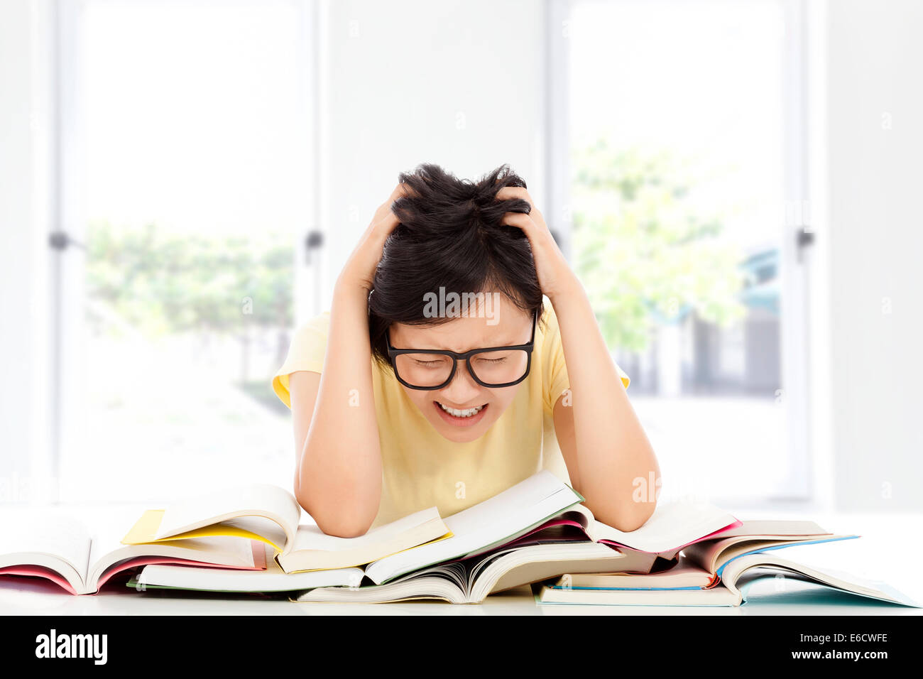 Gridando e stanco asiatica ragazza dello studente a casa Foto Stock