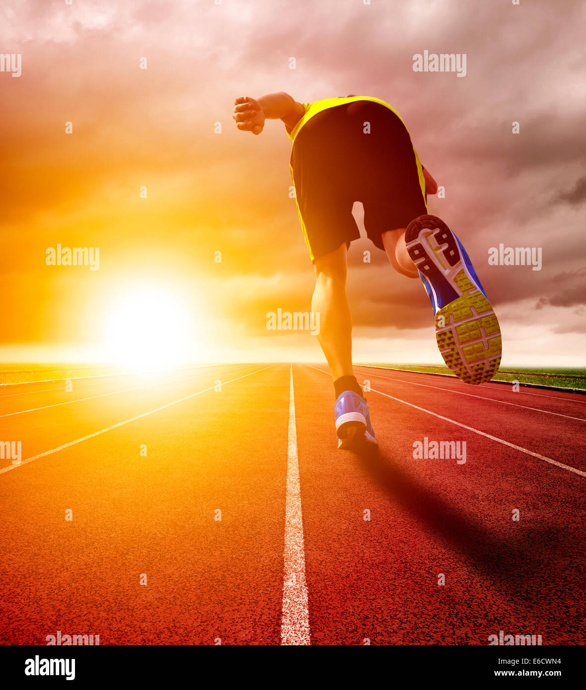 Atletica Giovane uomo che corre sulla pista con lo sfondo del tramonto Foto Stock