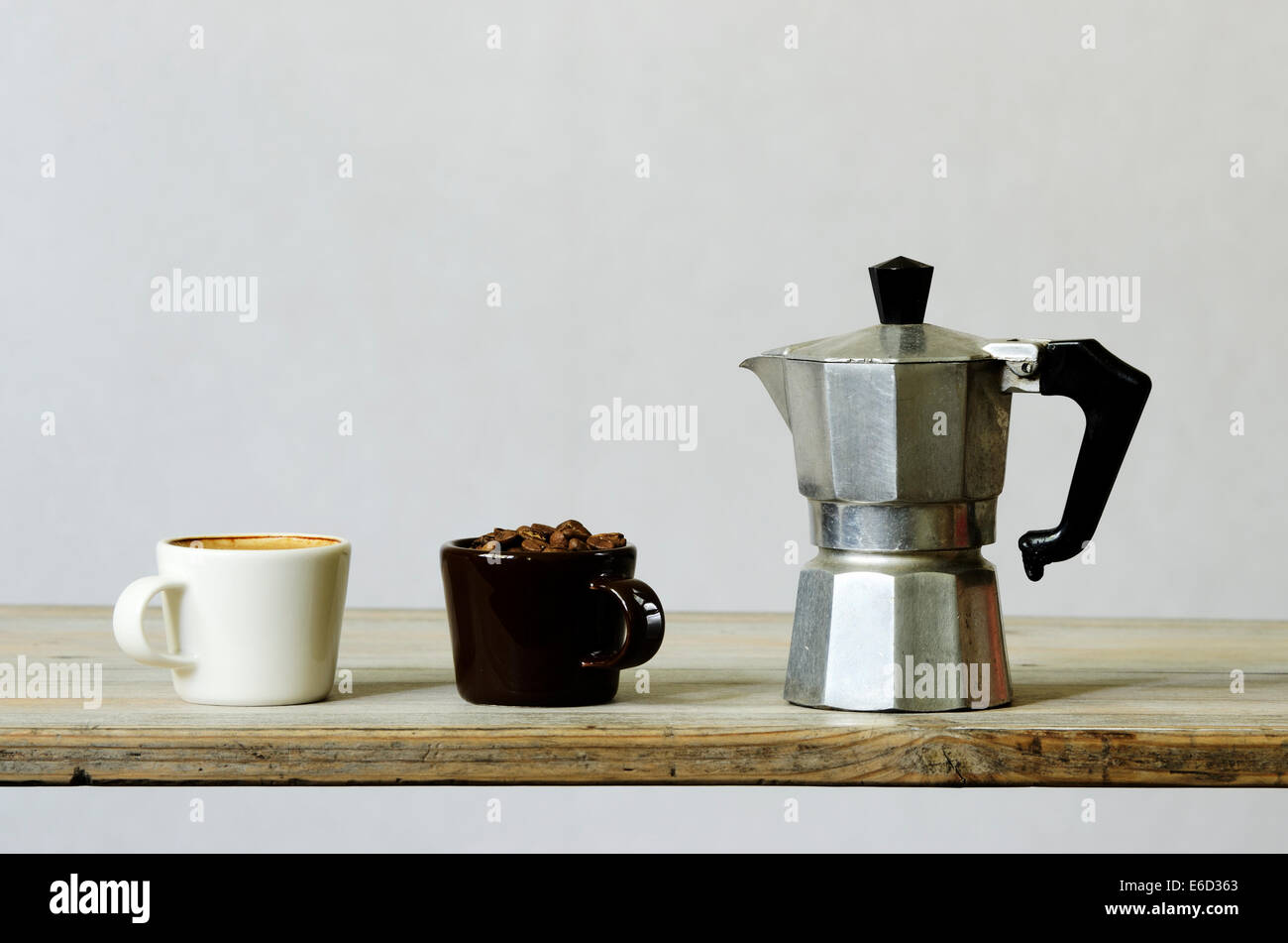 Due tazze di caffè e fagioli e percolatore su legno Foto Stock