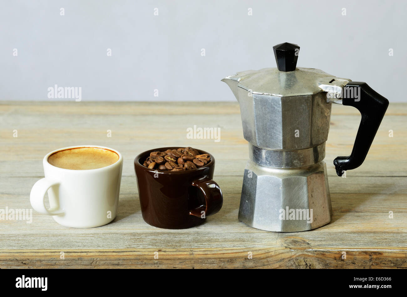 Due tazze di caffè e fagioli e percolatore su legno Foto Stock