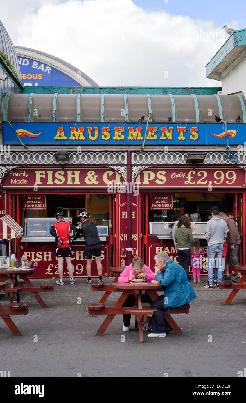 Turisti che si godono il pesce e patatine Central Pier di Blackpool, Lancashire Foto Stock