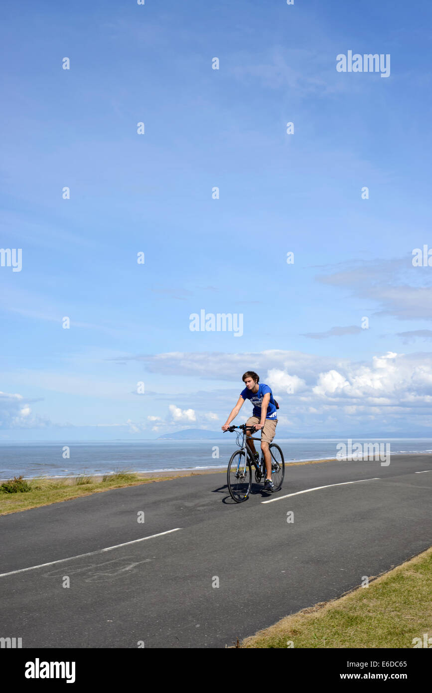 Giovane uomo equitazione Bicicletta sul sentiero costiero di Blackpool, Lancashire Foto Stock