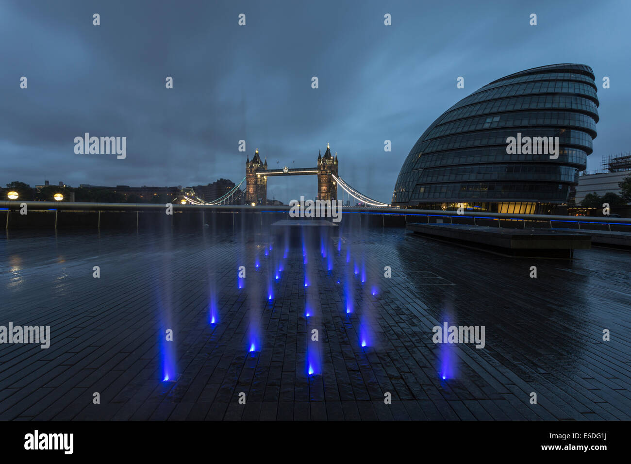 Fontana illuminata nella luce del mattino con il Municipio e il Tower Bridge di Londra, Inghilterra, Regno Unito Foto Stock