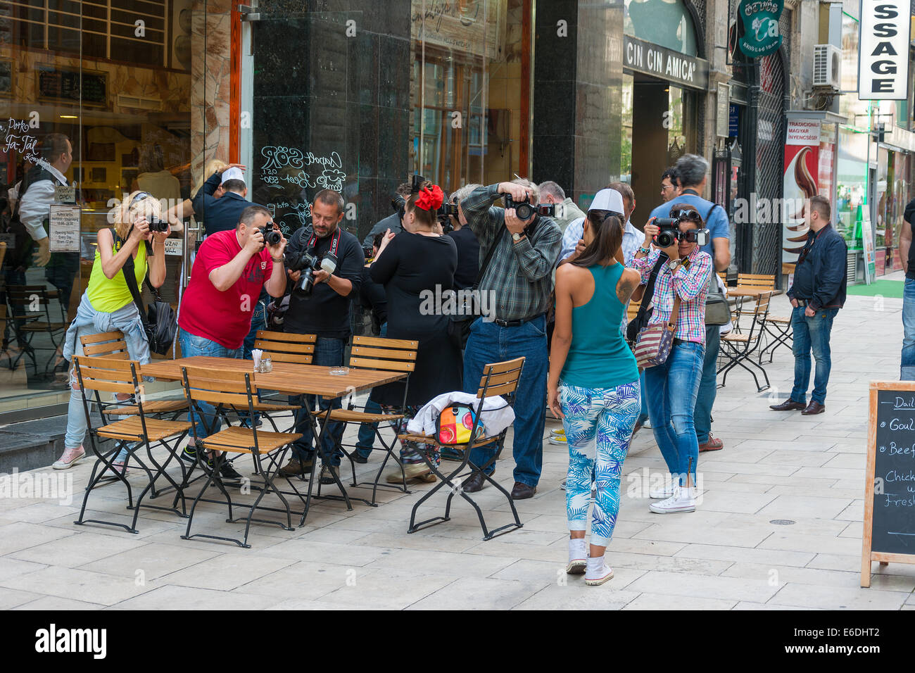 Gruppo di fotografi a fotografare un modello femminile su una strada di Budapest. Foto Stock