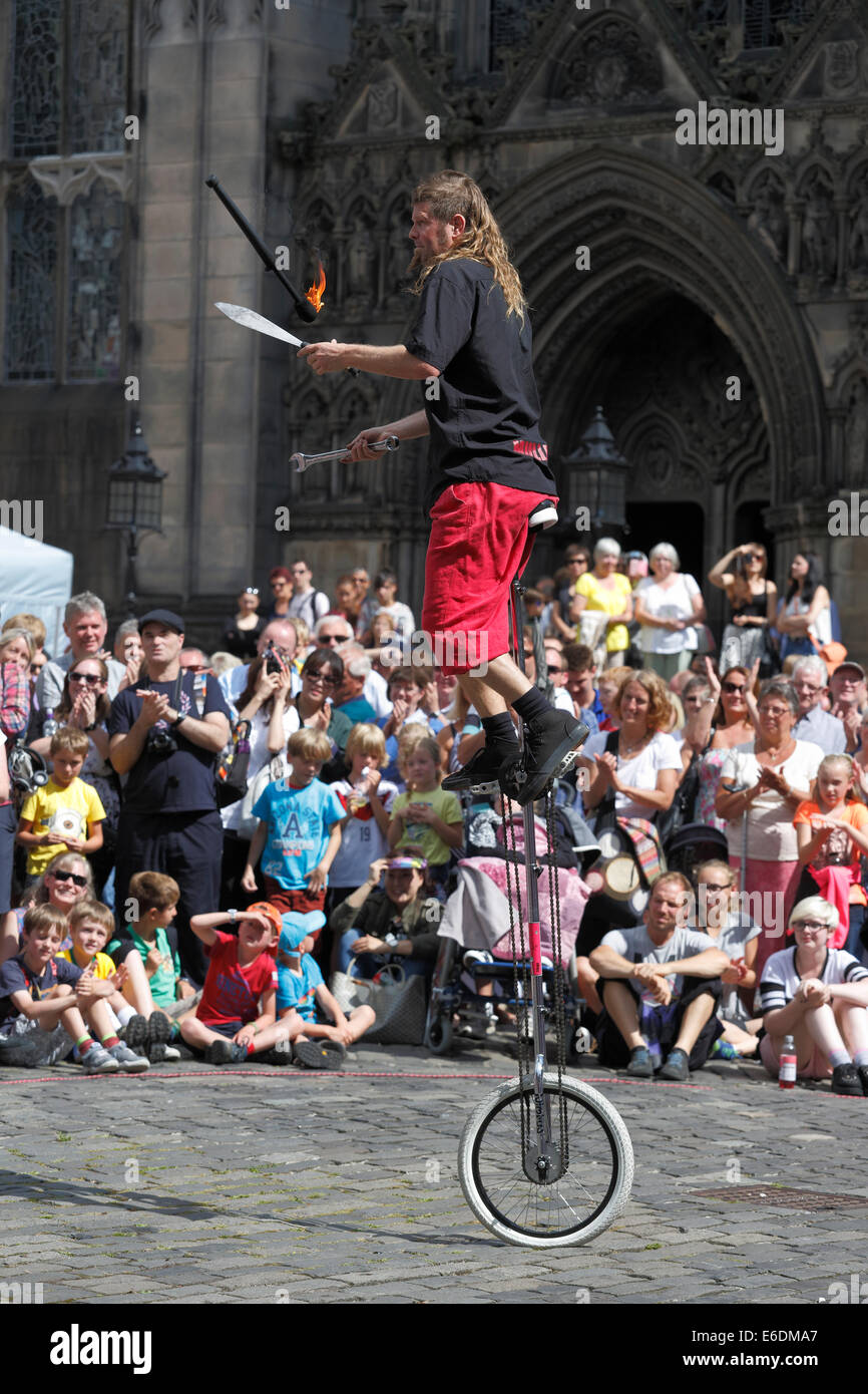 Street Performer Triglia uomo juggling su un monociclo durante il Festival di Edimburgo Fringe, Scotland, Regno Unito Foto Stock