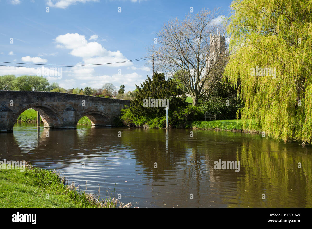 Il ponte ad arco sul fiume Nene a Fotheringhay con uno scorcio del suggestivo villaggio chiesa di Tutti i Santi, Northamptonshire, Inghilterra Foto Stock