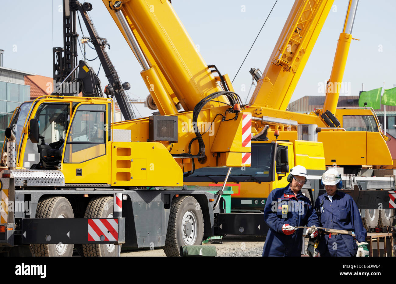 Costruzione di lavoratori e grandi gru mobili Foto Stock