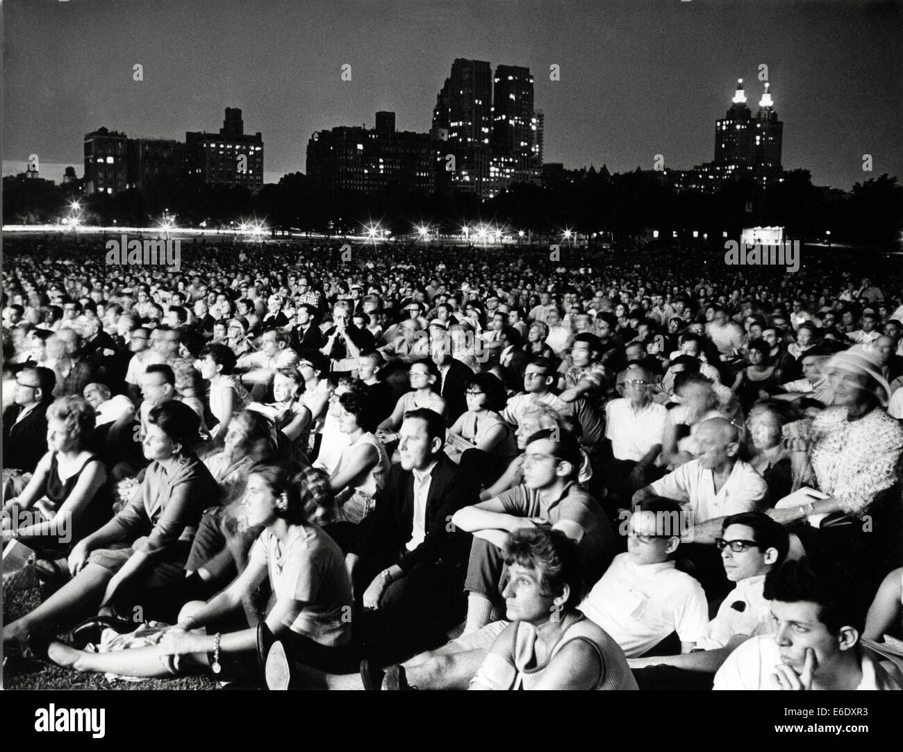 Grande folla ascoltare musica classica eseguiti da New York Philharmonic Orchestra di notte, al Central Park di New York City, Foto Stock