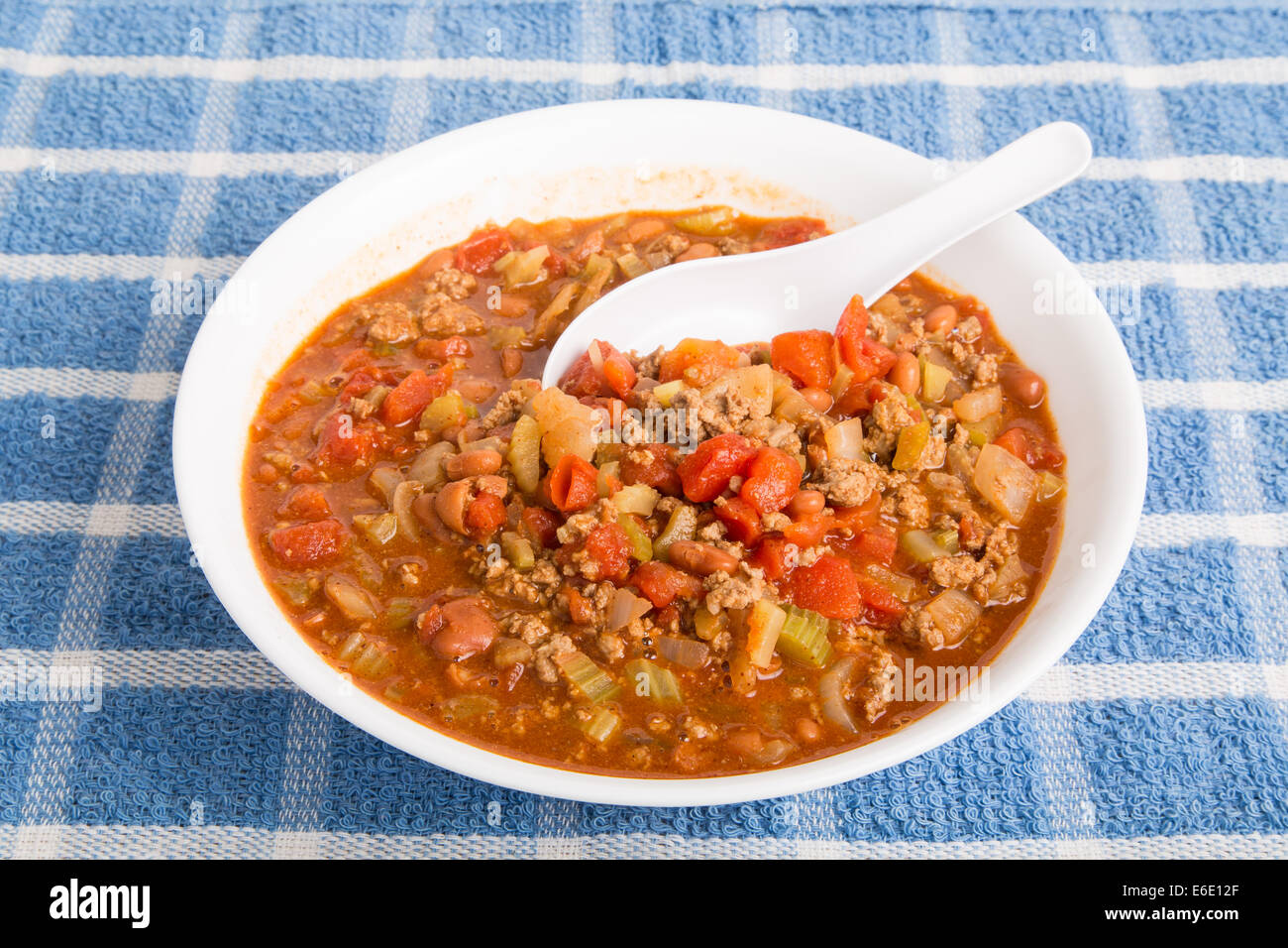 Caldo, peperoncino piccante in una ciotola di bianco, con cucchiaio Foto Stock