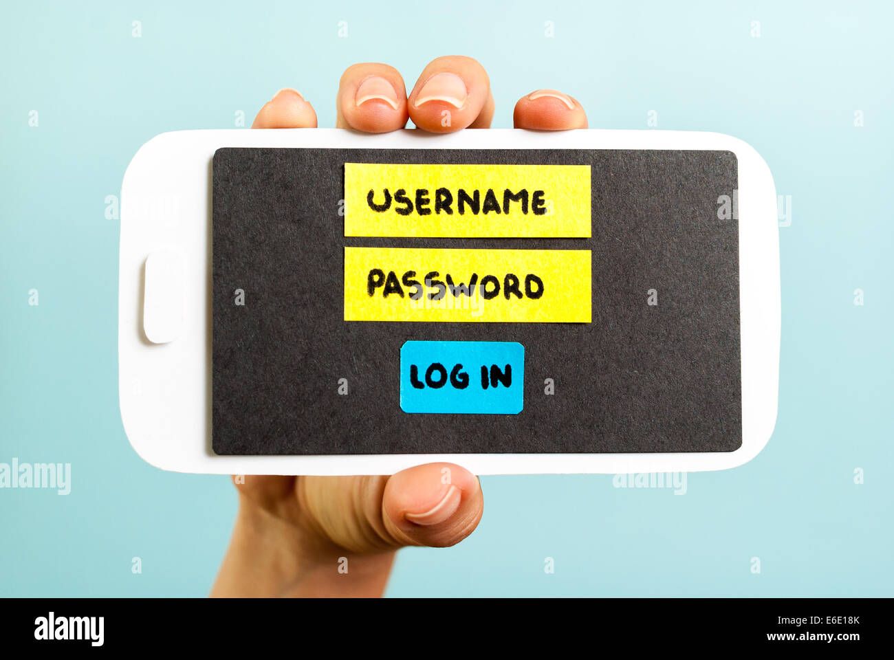 La mano che mostra un telefono concettuale con login form Foto Stock