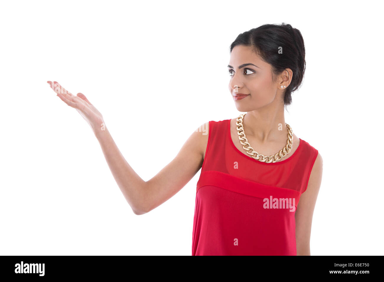 Isolato sorridente donna indiana in rosso la presentazione con la sua mano su sfondo bianco. Foto Stock