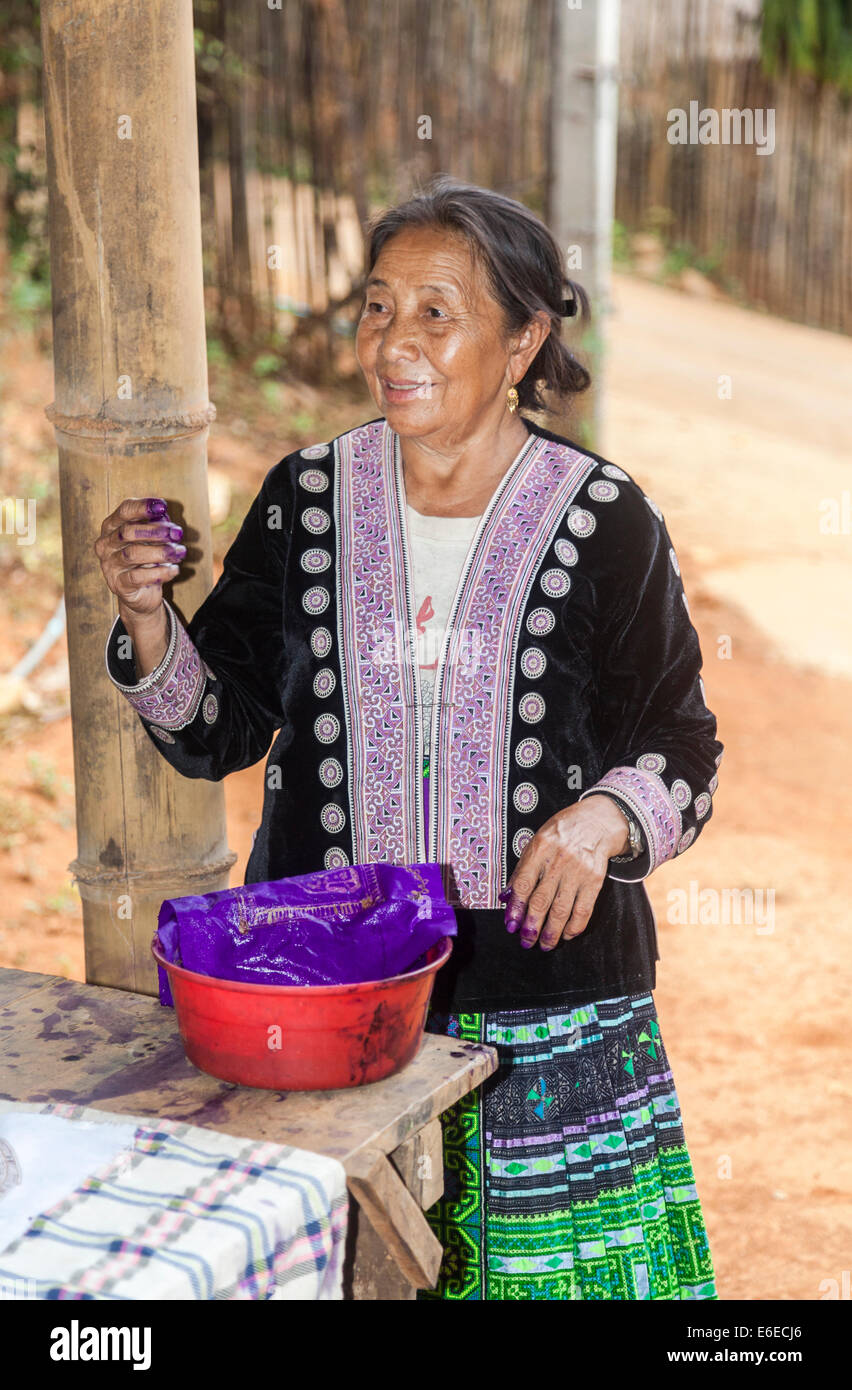 Hmong vecchia donna nel tradizionale colorato abito locale a dimostrazione della realizzazione dei Batik, Chiang Khong, provincia di Chiang Rai, Thailandia Foto Stock
