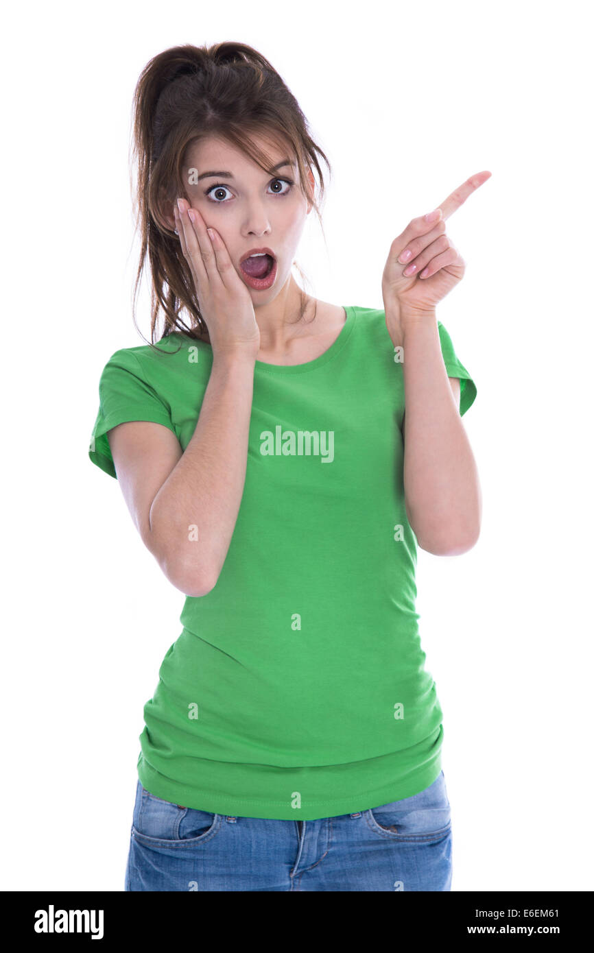 Scioccato e sorpreso giovane donna in maglia verde puntando con il dito su bianco. Foto Stock