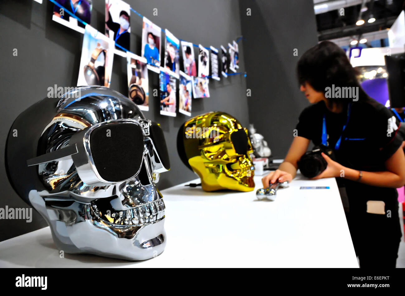 Pechino, Cina. Il 22 agosto, 2014. Un visitatore guarda al cranio-altoparlanti sagomato durante il Macworld/iWorld Asia 2014, un Apple periferiche e accessori il caso, a Pechino, capitale della Cina, e il agosto 21, 2014. I quattro giorni della manifestazione è iniziato giovedì a Pechino la China National Convention Center, che attrae oltre 300 espositori del mondo. Credito: Xinhua/Alamy Live News Foto Stock