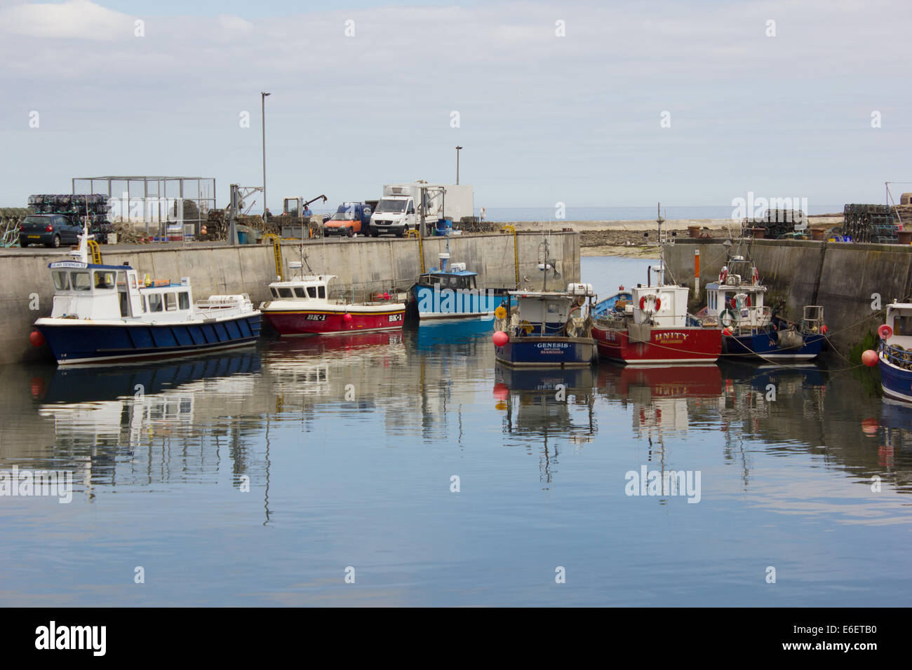Immagini riflesse di pesca e di viaggio barche ormeggiate nel porto, Seahouses, Northumberland, England, Regno Unito Foto Stock