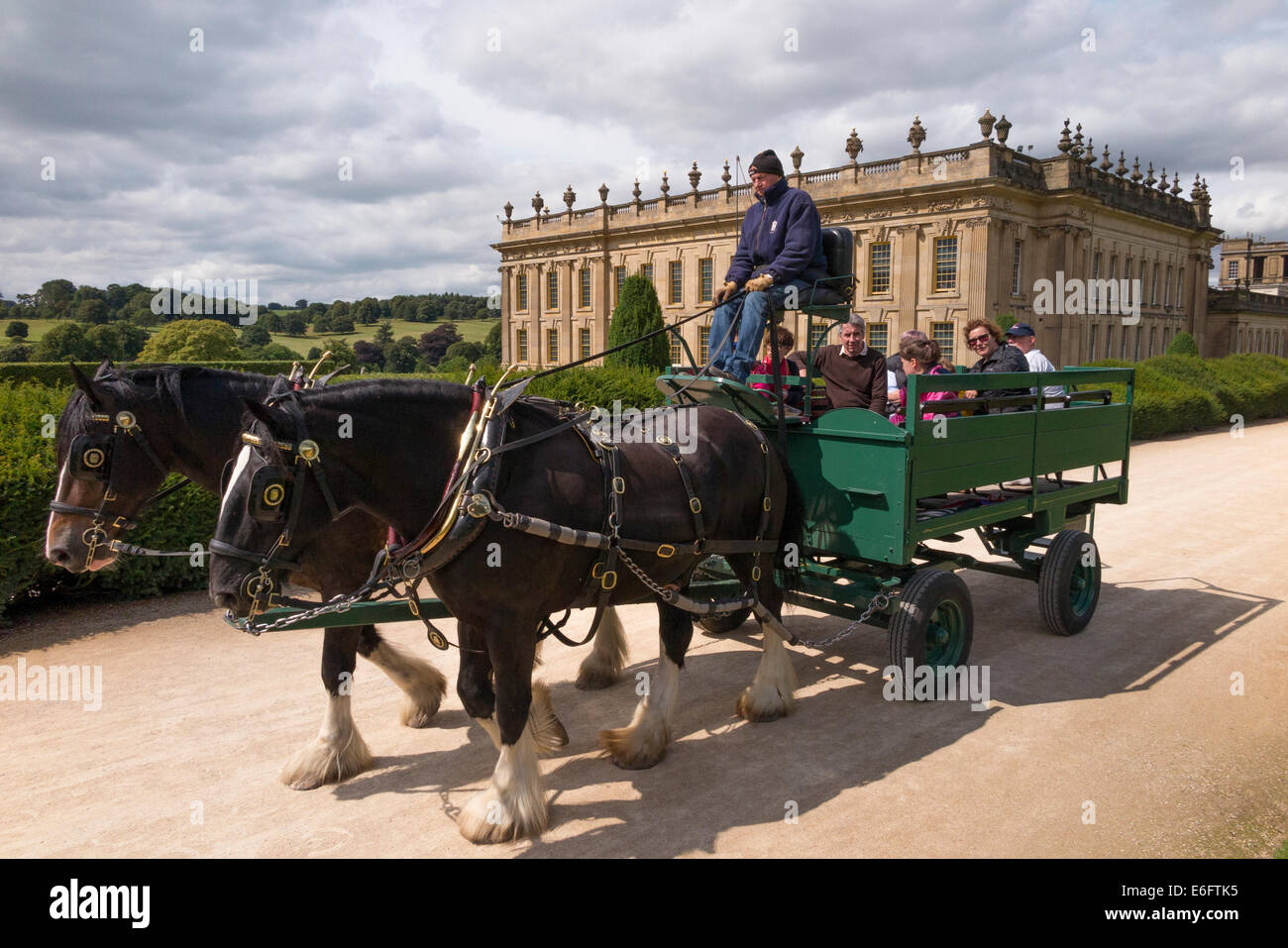 Cavallo e Carrozza turistica con driver e i turisti di marcia attraverso giardini esterni di Chatsworth House ( Sud fronti ) nr Bakewell nel Derbyshire. Regno Unito. Foto Stock