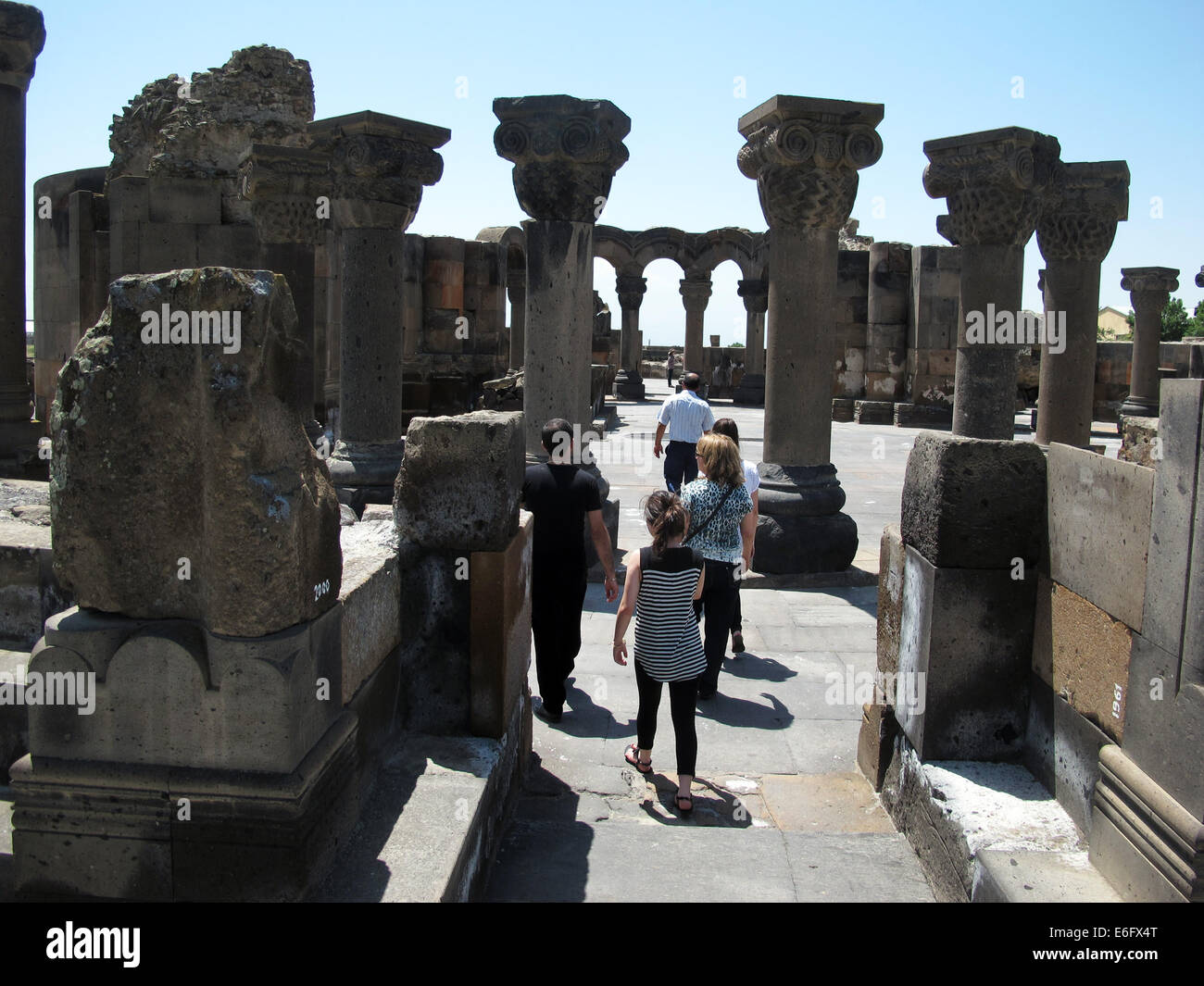 Visitatori passeggiata attraverso la rovina archeologica sito di Swartnoz in Etschmiadsin, Armenia, 22 giugno 2014. La distrutta chiesa gregoriana di Swartnoz, risalente al X secolo d.c. era la più antica e la più grande tetraconch chiesa di stile nella regione del Caucaso ed è considerato uno dei primi esempi di medievale di architettura armena e uno del più rinomato simboli architettonici della chiesa Armenian-Apostolic. La chiesa e il sito di scavo è un'UNESCO ha elencato la costruzione dal 2000. Foto: Jens Kalaene/dpa - nessun filo SERVICE - Foto Stock