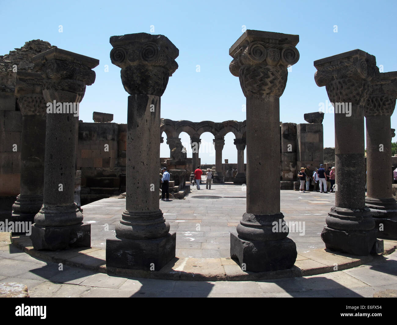 Visitatori passeggiata attraverso la rovina archeologica sito di Swartnoz in Etschmiadsin, Armenia, 22 giugno 2014. La distrutta chiesa gregoriana di Swartnoz, risalente al X secolo d.c. era la più antica e la più grande tetraconch chiesa di stile nella regione del Caucaso ed è considerato uno dei primi esempi di medievale di architettura armena e uno del più rinomato simboli architettonici della chiesa Armenian-Apostolic. La chiesa e il sito di scavo sono elencati UNESCO sito patrimonio mondiale dal 2000. Foto: Jens Kalaene/dpa - nessun filo SERVICE - Foto Stock