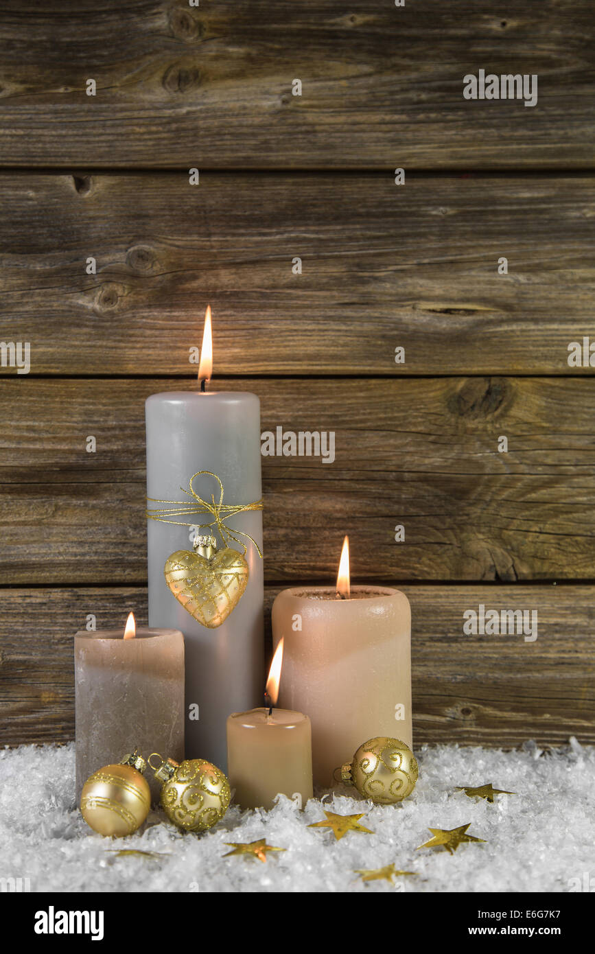 Golden tradizionali decorazioni natalizie con quattro masterizzazione beige avvento candele su sfondo di legno. Foto Stock