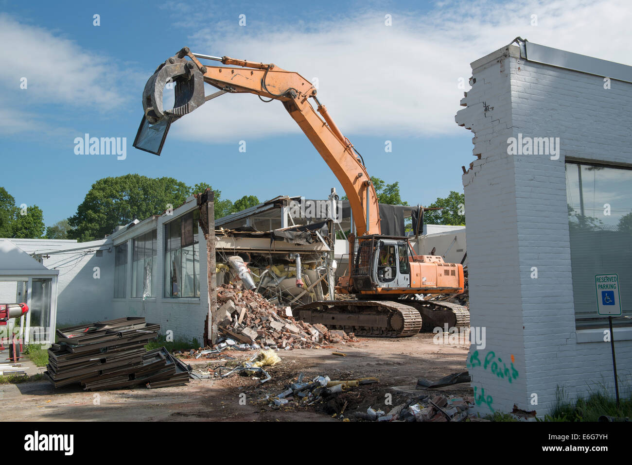 Escavatore con benna mordente facendo lavori di demolizione su edificio per  uffici a Norwalk, CT. Materiali ordinati per il riciclaggio Foto stock -  Alamy