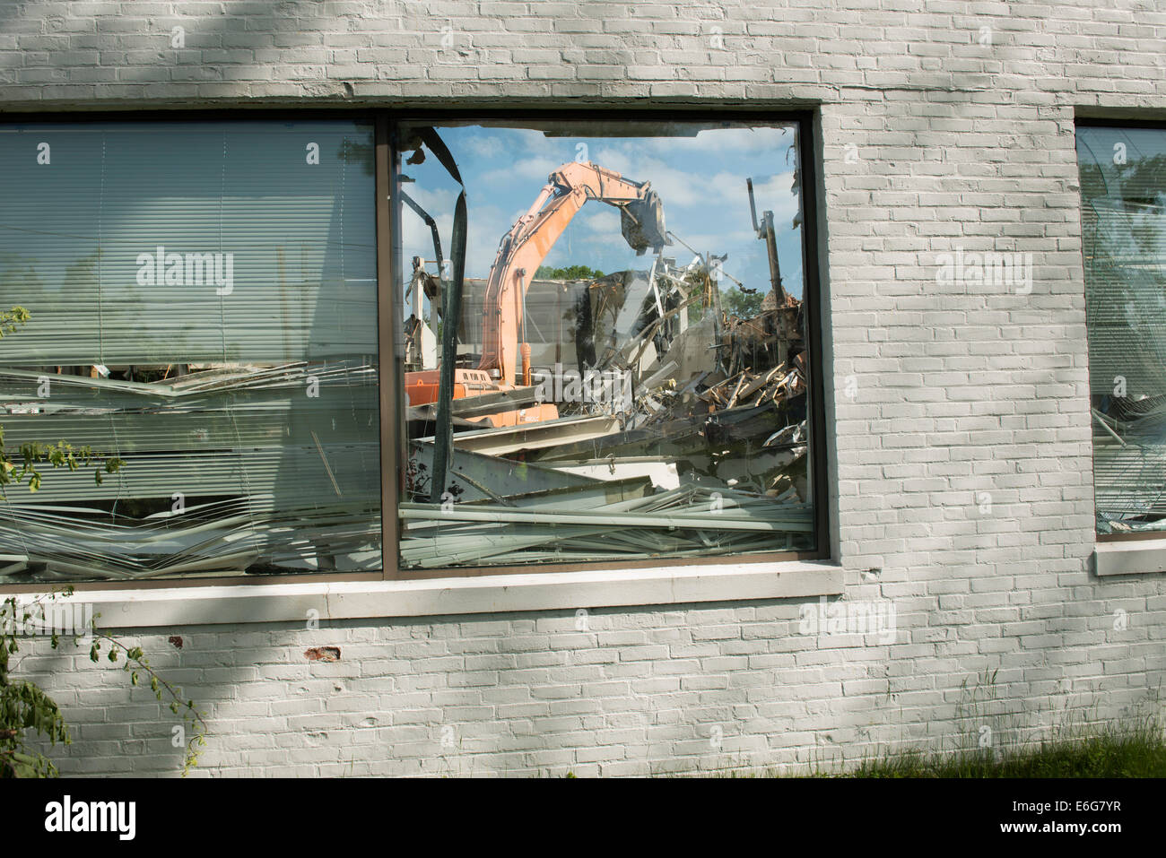 Escavatore con benna mordente facendo lavori di demolizione su edificio per uffici a Norwalk, CT. Foto Stock