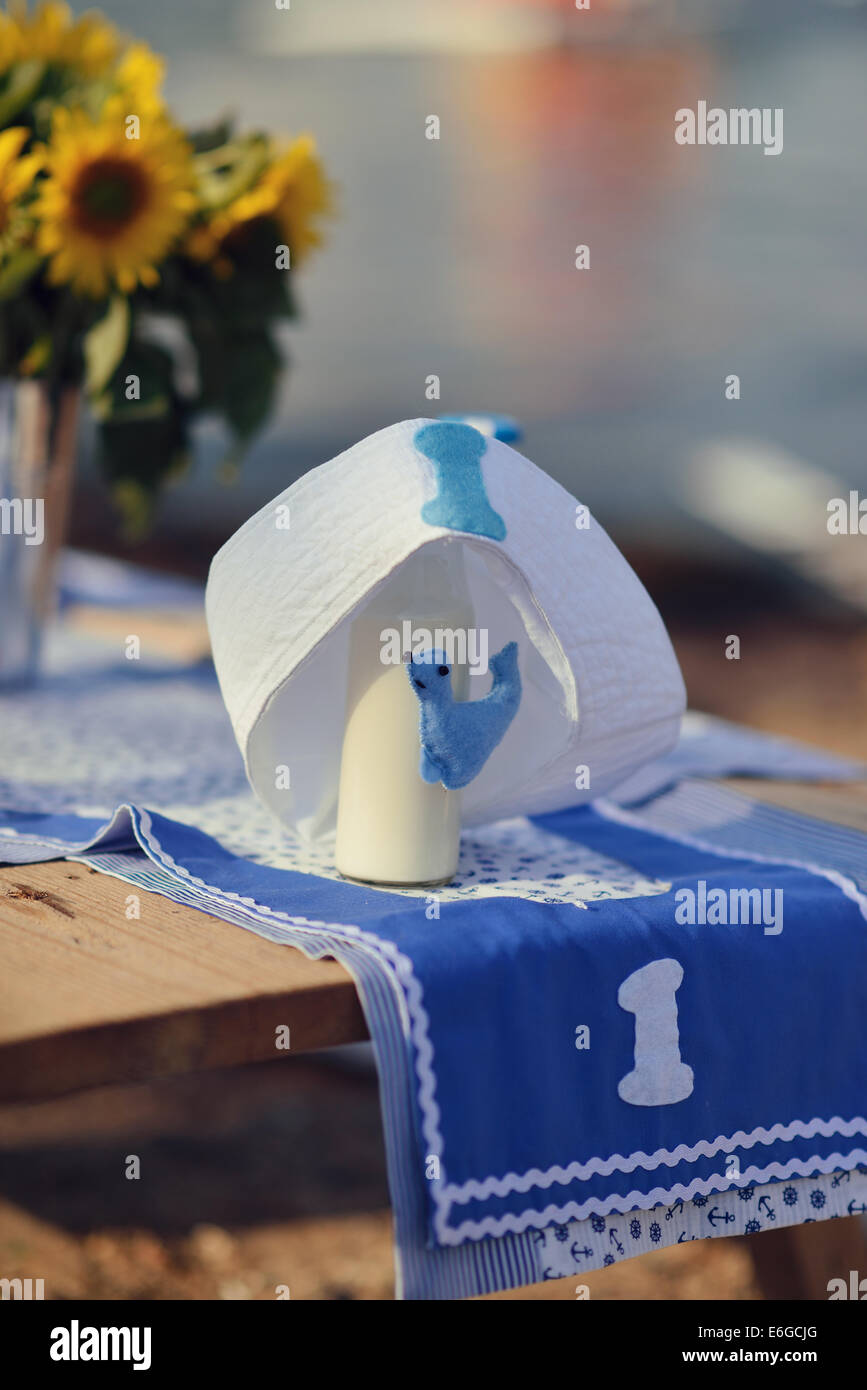 Outdoor tavolo in legno con una bottiglia di latte e un vaso con girasoli Foto Stock