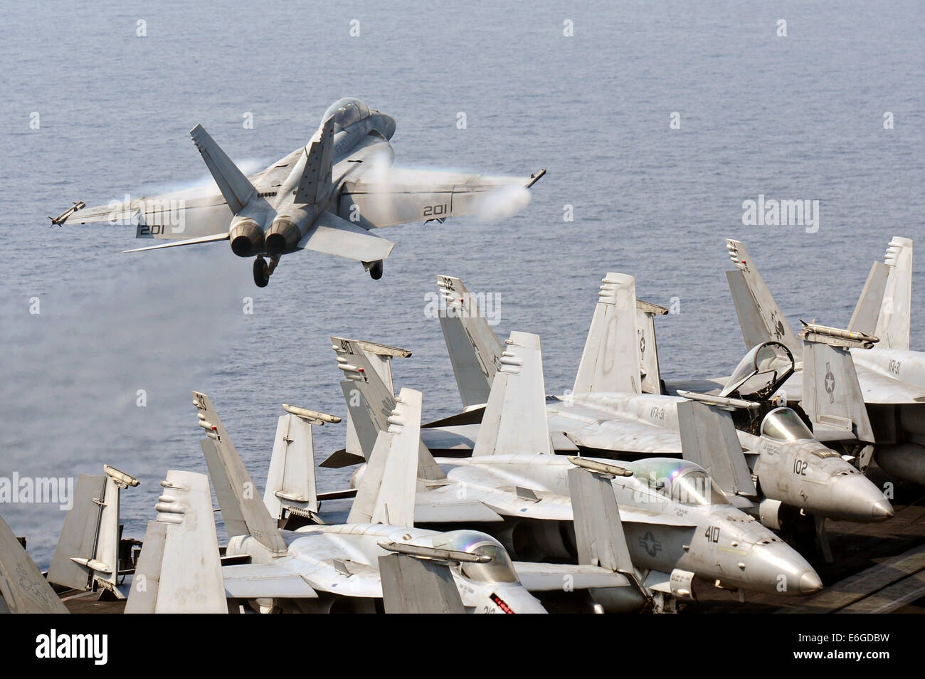 Un US Navy F/A-18F Super Hornet fighter aircraft decolla dal ponte di volo della portaerei USS George H.W. Bush su una missione per sostenere l'esercito iracheno il 16 agosto 2014. Il presidente Obama autorizzato incursioni aeree mirate a proteggere il personale degli Stati Uniti dagli estremisti noto come lo stato islamico in Iraq e il levante. Foto Stock