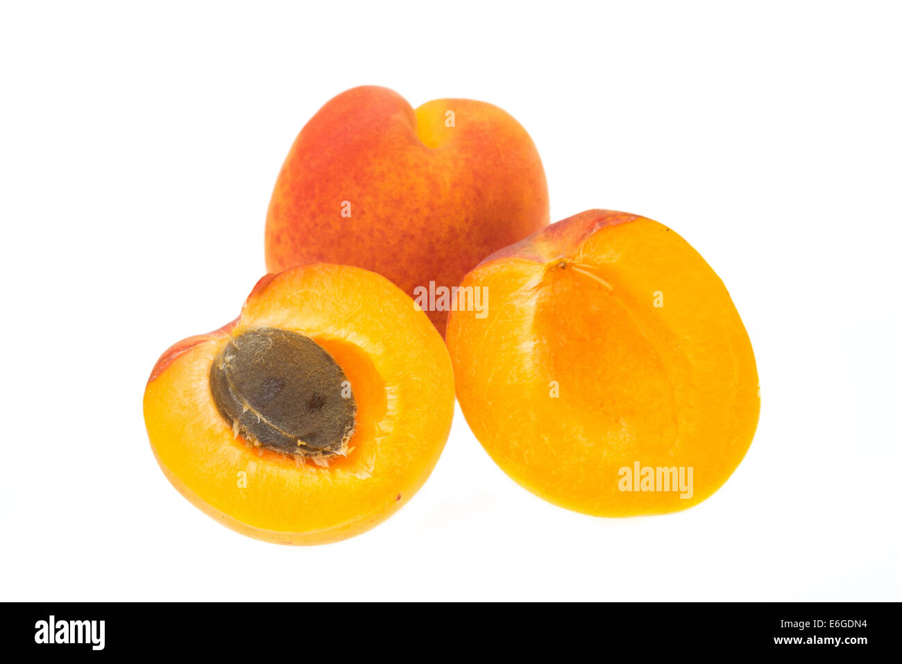 Albicocche, tutta la frutta e tagliate a metà - studio shot con uno sfondo bianco Foto Stock