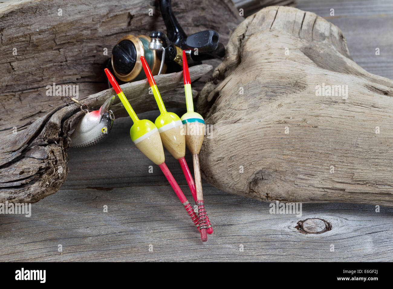 Primo piano immagine orizzontale di oggetti di pesca costituito da galleggianti, aspo, unica esca tutti poggianti contro di età driftwood Foto Stock