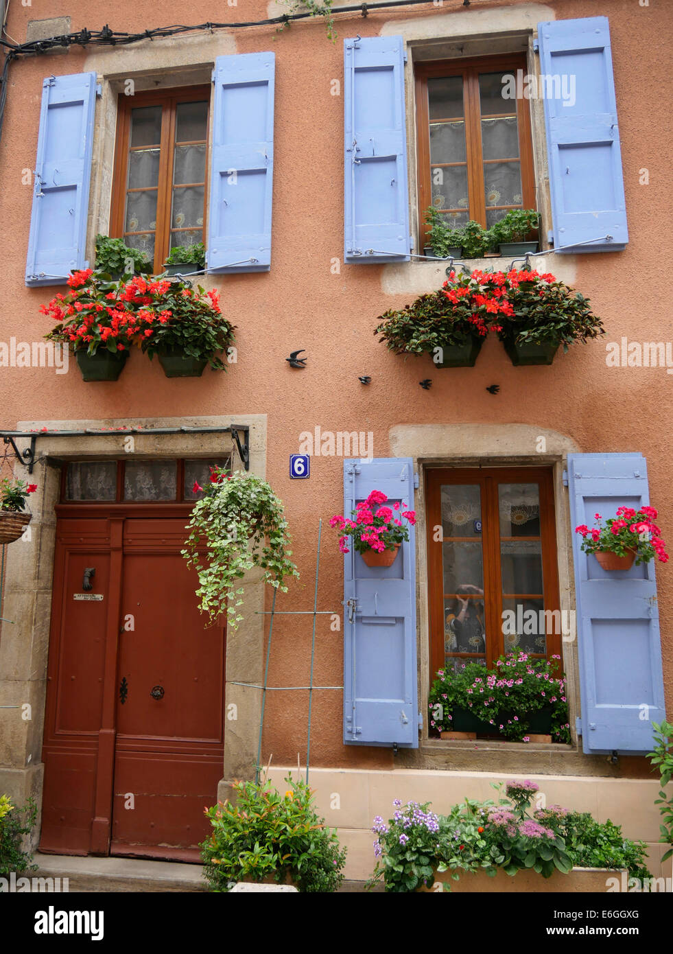 Persiane blu e cesti di fiori al di fuori di una casa francese di Mirepoix Francia Foto Stock