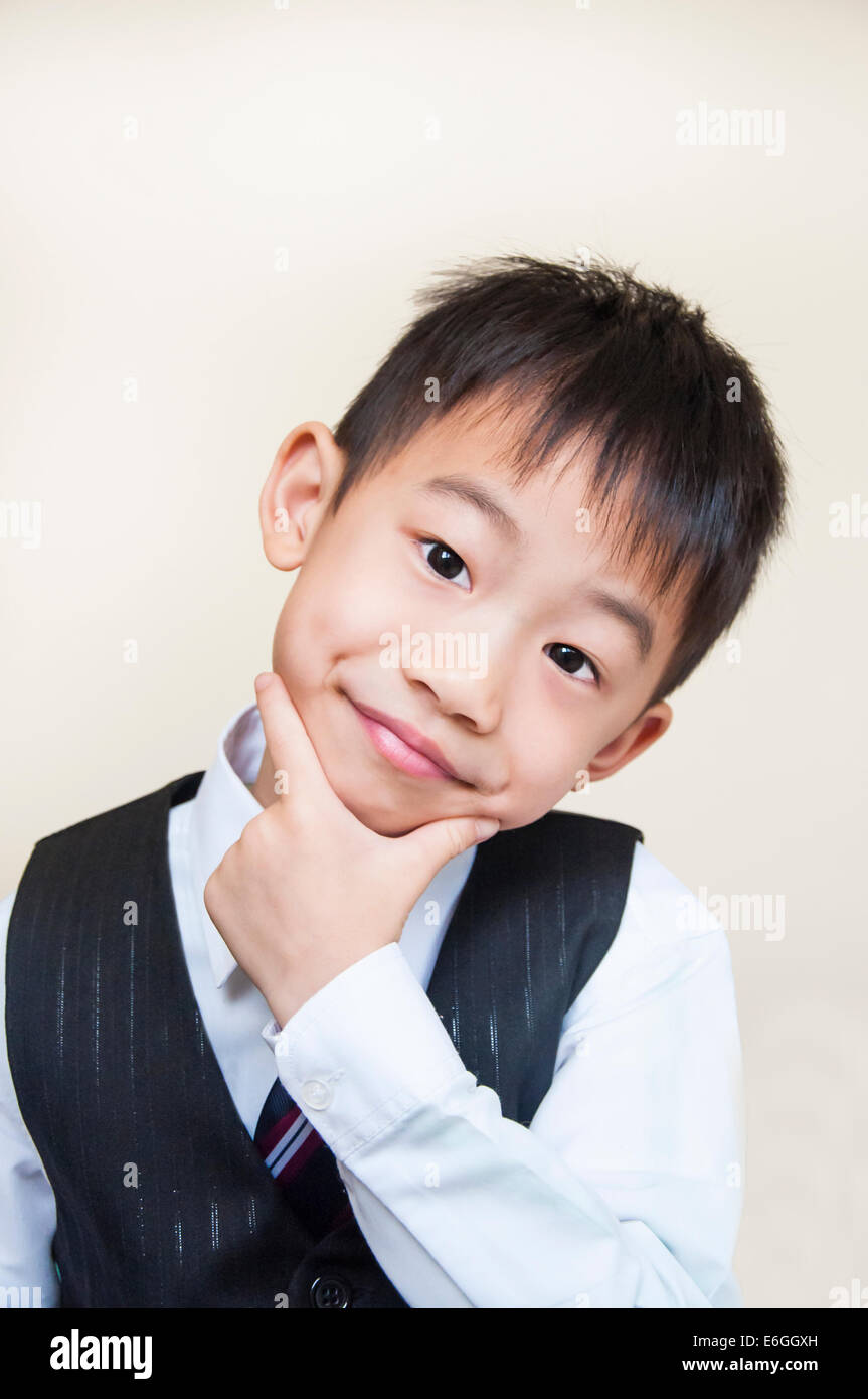 Ragazzo sorridente mise la mano sul mento Foto Stock